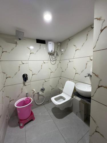 a bathroom with a toilet and a sink at HOTEL GOLDEN VIEW in Vadodara