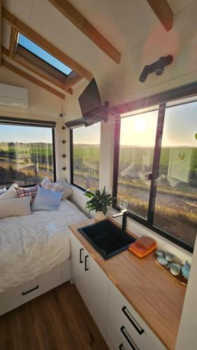 a small bedroom with a bed and a sink at Coastal Haven - Port Fairy Tiny Homes in Killarney