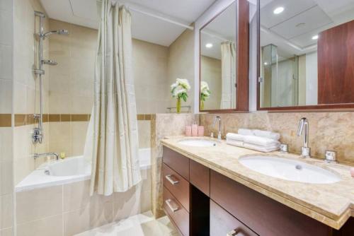 une salle de bain avec deux lavabos, une baignoire et une douche dans l'établissement Bellavista - Magnificent - 3BR - 29 Boulevard - Partial Burj Khalifa & Fountain Views, à Dubaï