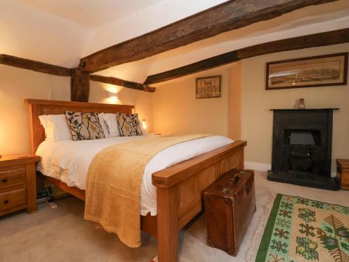 沃本的住宿－Winter Cottage，一间卧室设有一张大床和一个壁炉