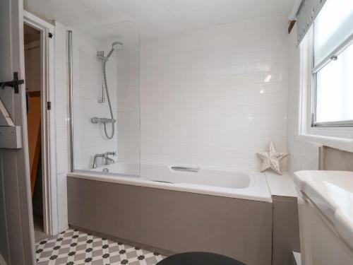 a bathroom with a bath tub and a shower at Winter Cottage in Sudbury