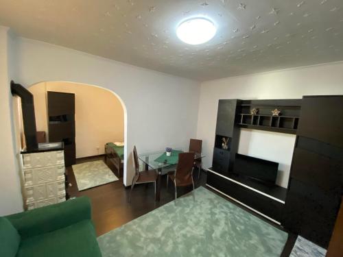 een woonkamer met een tafel en een slaapkamer bij Apartament Borsec in Borsec