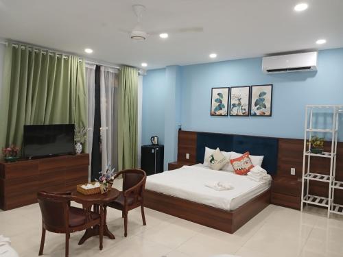 a bedroom with a bed and a table and a television at Hà Nội Quán Homstay in Phu Quoc