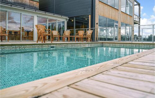 a swimming pool with chairs next to a building at Stunning Apartment In Stjrnhov With House Sea View in Stjärnhov