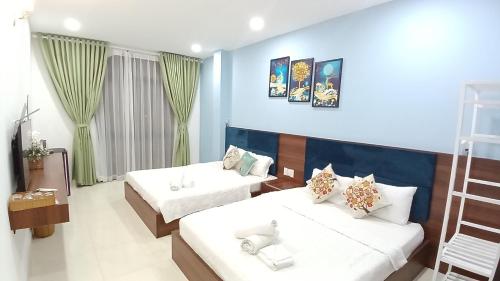 a bedroom with two beds and a blue wall at Hà Nội Quán Homstay in Phu Quoc