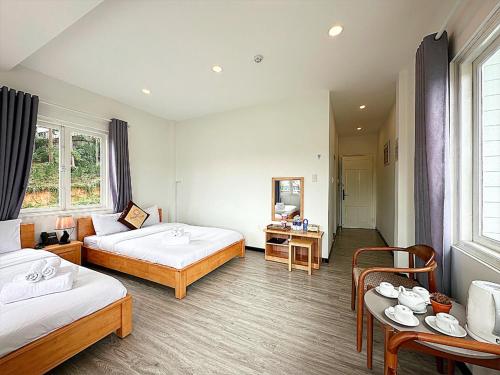 a hotel room with two beds and a table at The Cherry Hill Hotel in Xuan An