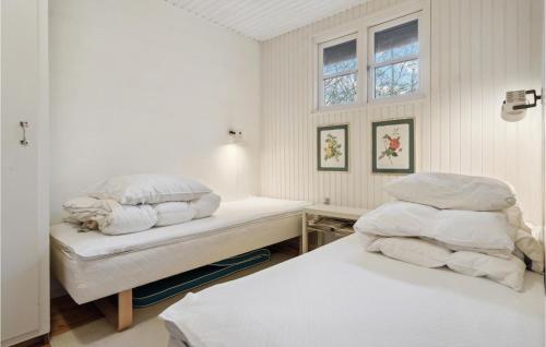een witte slaapkamer met 2 bedden en een raam bij Stunning Home In Allingbro With Wifi in Allingåbro