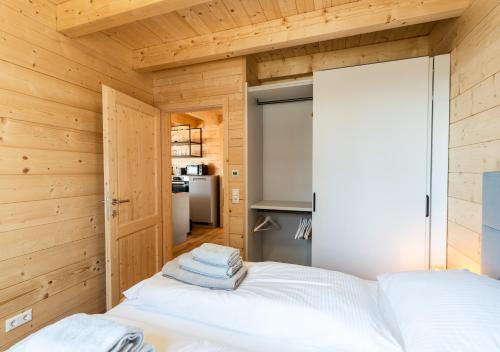 a bedroom with wooden walls and a bed with towels at 1A Chalet 'Horst' Wandern, Grillen, Panorama Sauna! in Klippitztorl