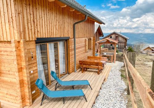 a deck with chairs and a bench on a cabin at 1A Chalet 'Horst' Wandern, Grillen, Panorama Sauna! in Klippitztorl
