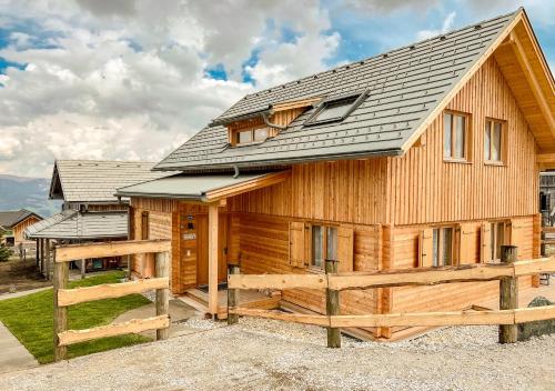 a log cabin with a metal roof and a fence at 1A Chalet 'Horst' Wandern, Grillen, Panorama Sauna! in Klippitztorl