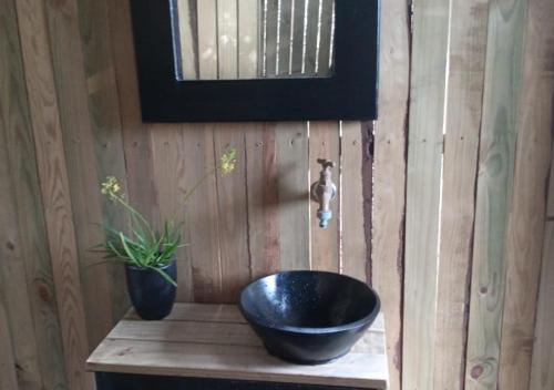 baño con lavabo negro en una pared de madera en The Wild - Glamping in Wilderness, en Wilderness