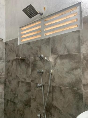a bathroom with a shower with a glass door at Bethany Homestay in Katunayaka
