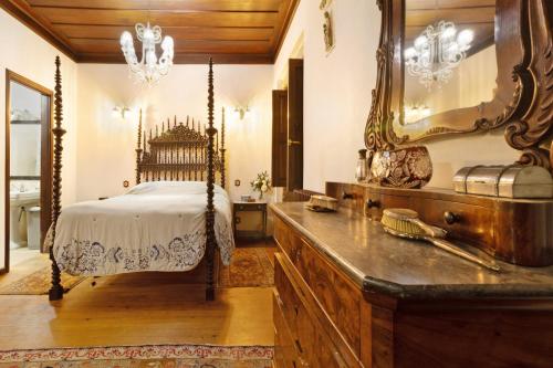 Fontoura的住宿－Quinta de San Antonio，一间卧室配有一张带镜子和梳妆台的床