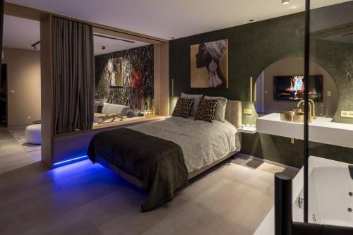 a bedroom with a large bed and a bathroom at SuiteDreams - Bali Suite Liège in Liège