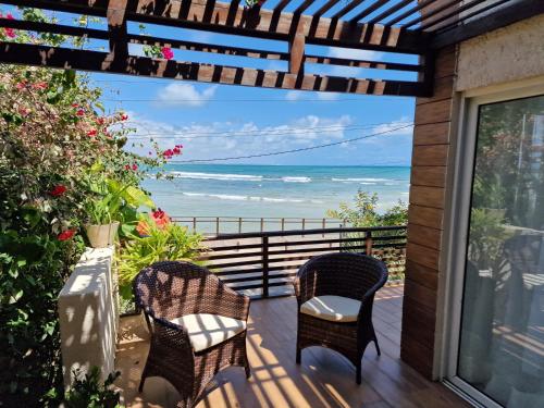 a balcony with two chairs and a view of the ocean at Casa Surucuá com localização espetacular frente à Praia do Centro de Pipa - 2 a 4 quartos suite in Pipa