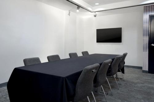 a conference room with a black table and chairs at Aloft Oklahoma City Downtown – Bricktown in Oklahoma City