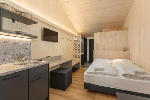 Kleines Zimmer mit einem Bett und einem Waschbecken in der Unterkunft Hotel Ferienalm in Schladming