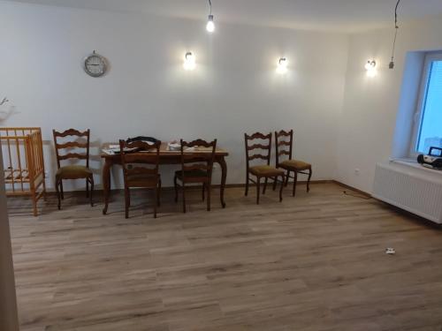 a dining room with a wooden table and chairs at Apartmány u Martina in Javorník
