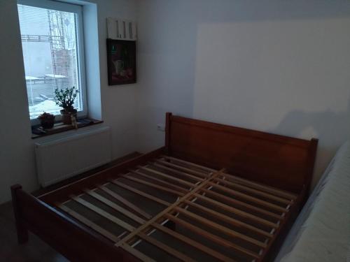 a wooden bed in a room with a window at Apartmány u Martina in Javorník