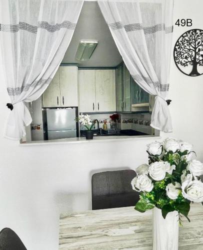 a kitchen with a vase of flowers in a room at TIMORA SEA VIEW New Apart' Hipocampos in Calpe