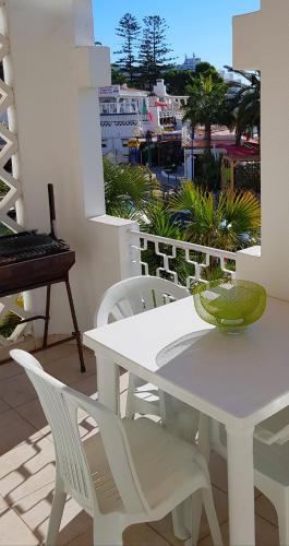 a white table and chairs on a balcony with a piano at Praia Oura Sunset in Albufeira