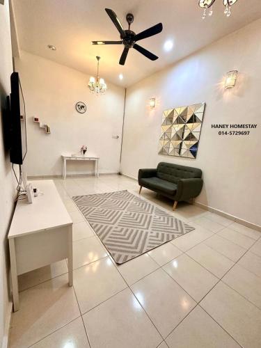 a living room with a couch and a ceiling fan at Haney Homestay in Kuantan