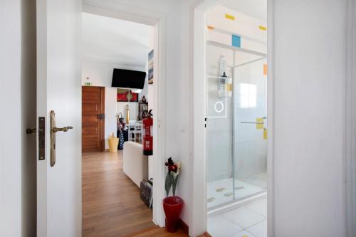 a bathroom with a shower and a glass door at Apartamento da Alegria in Caldas da Rainha