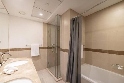ドバイにあるBellavista - Dazzling High Floor - 2BR - 29 BOULEVARD - Burj Khalifa & Fountain Viewのシャワー、洗面台、浴槽を備えたバスルーム