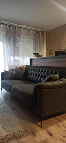 a large black couch in a living room at Apartman Dior - sauna, self check in in Belišće