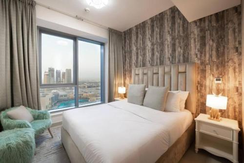 ドバイにあるBellavista - Dazzling High Floor - 2BR - 29 BOULEVARD - Burj Khalifa & Fountain Viewの大きなベッドと大きな窓のある寝室