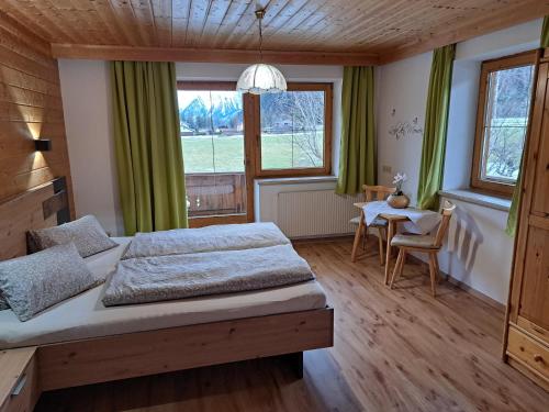 1 dormitorio con 1 cama y 1 mesa en Tischlerhof, en Lago Achen