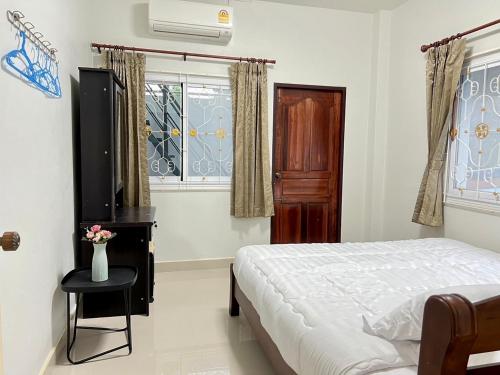 a bedroom with a bed and a table and a window at BAAN OZONE HY2 in Hat Yai