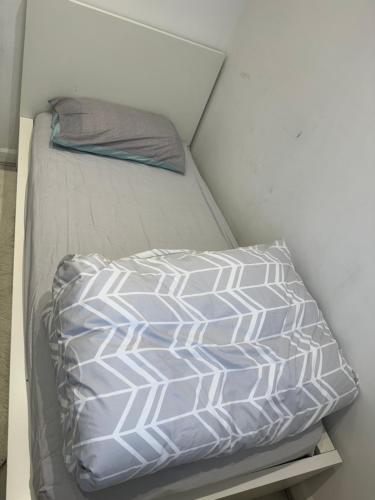 a bed in a room with a pillow on it at Single Room in Canvey