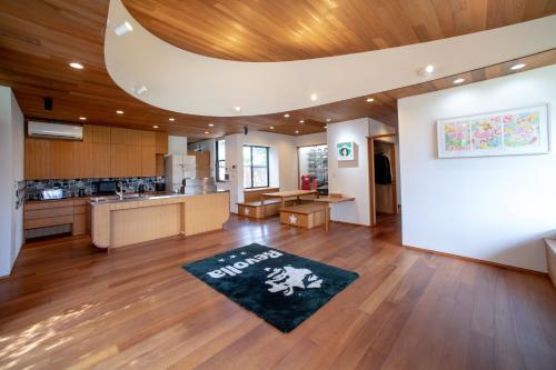 Villa Revo Shizuoka Japan في Makinohara: مطبخ مفتوح وغرفة معيشة مع سجادة على الأرض
