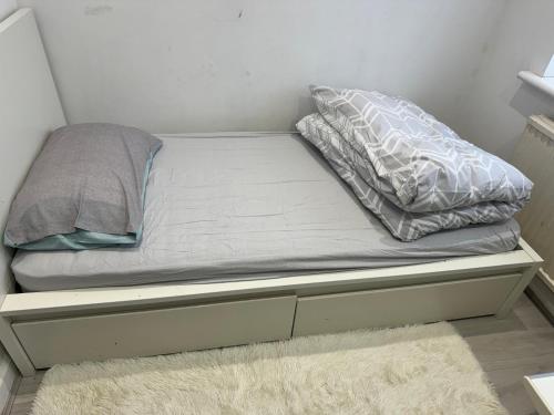 a bed with two pillows on top of it at Single Room in Canvey