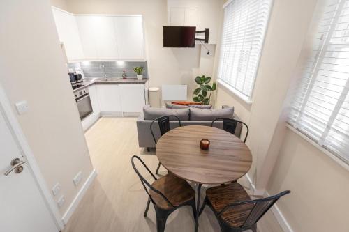 a room with a table and chairs and a kitchen at Quaint Homes in Chelsea in London
