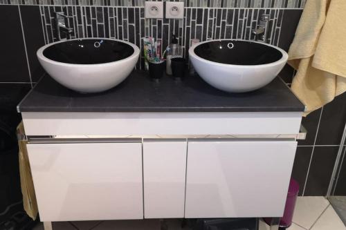 due lavandini su un bancone nero in bagno di Villa avec tout le confort dans le livradois forez a Saint-Genès-la-Tourette