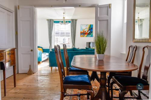 a dining room with a wooden table and chairs at The Georgian House in Weymouth