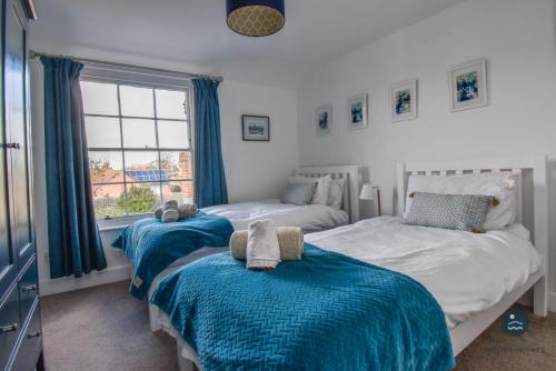 a bedroom with two beds and a window at The Georgian House in Weymouth