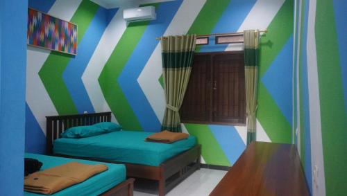 a room with two beds and a striped wall at JOGLO Greenhouse in Ngemplak