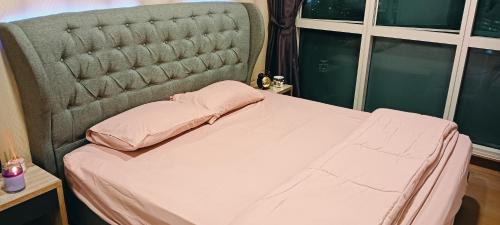 a bed with a headboard with a pink pillow on it at 超赞海景高级公寓 浪漫香薰浴缸泡澡 Nexflix YouTube WiFi 喜欢浪漫宁静的您怎可错过 in Nusajaya