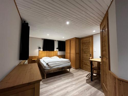 a bedroom with a bed and a desk in it at Gite "Les Essis" in Gérardmer