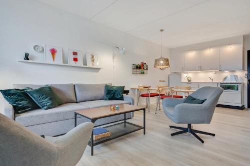een woonkamer met een bank en een tafel bij By the sea - Linen and towels included in Fåborg