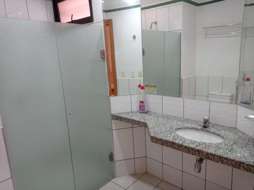 La salle de bains est pourvue d'un lavabo et d'un miroir. dans l'établissement Rio Quente Luupi - Apartamento - 229 P, à Rio Quente