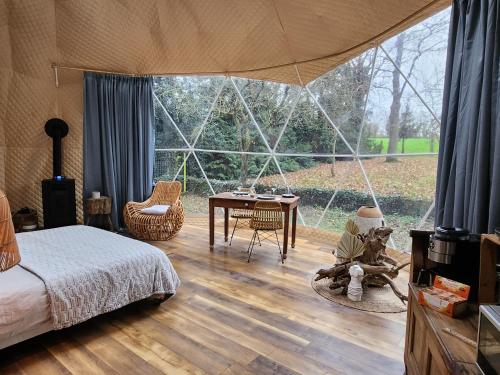 1 dormitorio con cama, mesa y ventana grande en Dôme magnifique avec spa 
