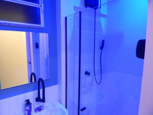 La salle de bains est pourvue d'une douche en verre et d'un lavabo. dans l'établissement Flat Atlântica Alto luxo - Posto 6 Copacabana, à Rio de Janeiro