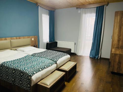 a bedroom with a large bed and blue walls at Hotel Shgedi Mestia in Mestia