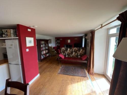 a living room with a red couch and a room with at Oskamull Farmhouse in Lagganulva