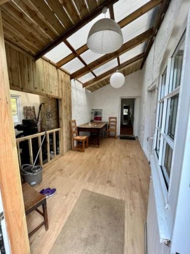a living room with a wooden floor and a table at Oskamull Farmhouse in Lagganulva