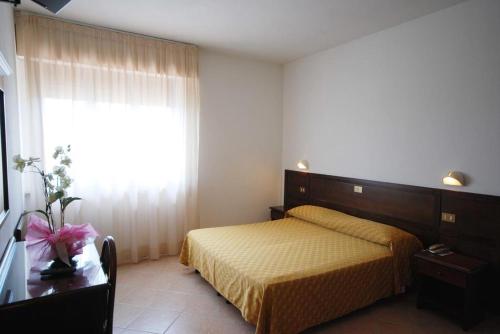 a bedroom with a bed and a large window at Hotel Astra-Chianciano Terme in Chianciano Terme